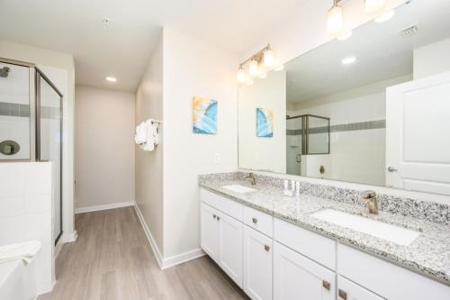 a bathroom with two sinks and a large mirror at New Modern Vista Cay Reserve Condo - 5006 in Orlando