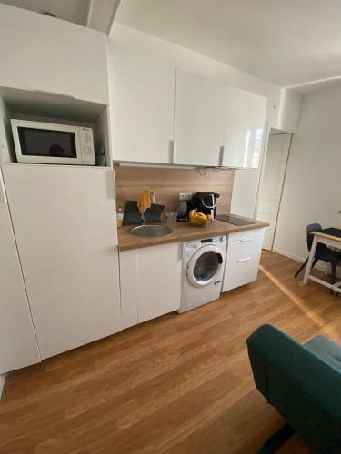 une cuisine avec un évier et une machine à laver dans l'établissement Cosy flat near Parc des Princes, à Boulogne-Billancourt