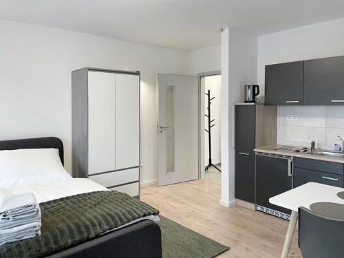 a bedroom with a large bed and a kitchen at Board Inn - Haus Regensburg in Regensburg