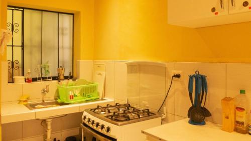 uma cozinha com um fogão e um lavatório em CASA MAYNAS BARRANCO em Lima