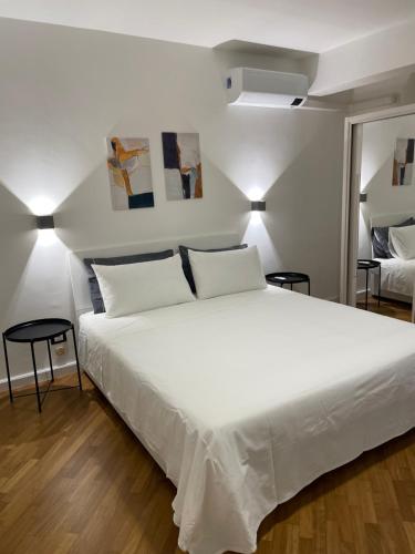 1 Schlafzimmer mit einem großen weißen Bett mit 2 Stühlen in der Unterkunft Baaria house in Bagheria