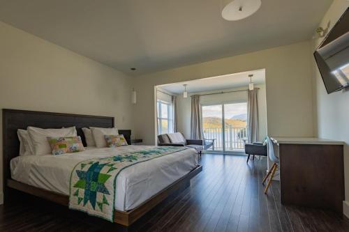 a bedroom with a large bed and a balcony at The Tides Inn in Norris Point