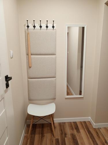 a white chair in a room with a mirror at SILESIAN CORNER Katowice in Katowice