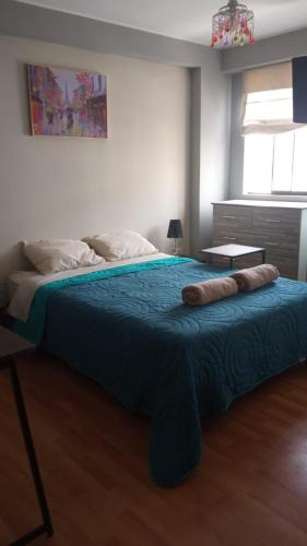 リマにあるApartamento amplio, tranquilo y centricoのベッドルーム1室(大型ベッド1台、青い毛布付)