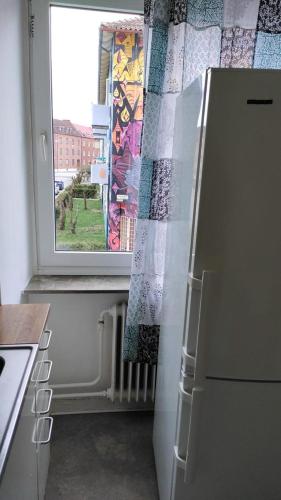 a kitchen with a refrigerator and a window at Full Apartment in Malmö