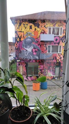 un edificio cubierto de graffitis con plantas delante de él en Full Apartment, en Malmö