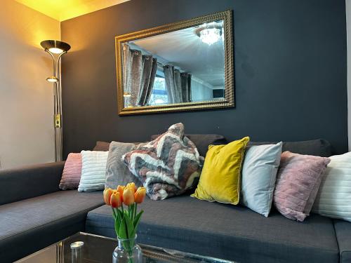 ein Wohnzimmer mit einem Sofa mit Kissen und einem Spiegel in der Unterkunft Marton Apartments in Marton