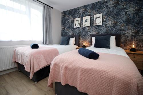 a bedroom with two beds with pink and blue sheets at Countryside Gem - Tranquil Escape in Bath in Bath