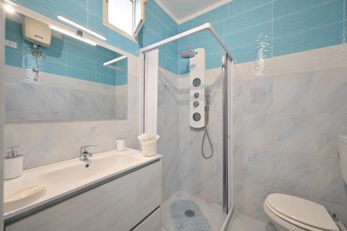 a bathroom with a shower and a toilet and a sink at Casetta Geró in Ischia