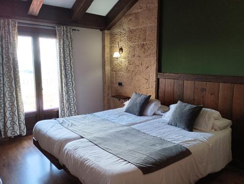 1 dormitorio con 1 cama grande y pared verde en Hotel Rural los Tadeos, en Zahara de la Sierra