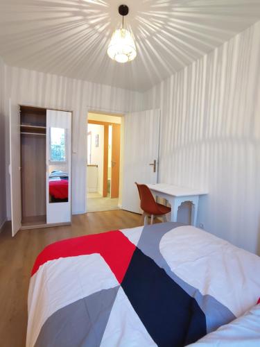 - une chambre avec un lit rouge blanc et bleu et un bureau dans l'établissement Appartement lumineux et spacieux 70m2 proche de tout - 3 chambres, à Nantes