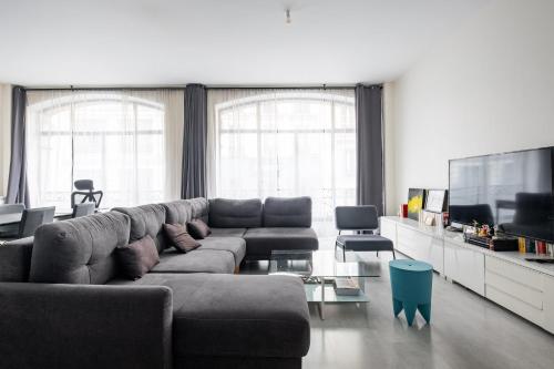 un salon avec un canapé et une télévision à écran plat dans l'établissement Veeve - Halles Heaven, à Paris