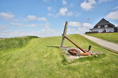 a sign in the grass next to a road at Anker's Hörn - Hotel & Restaurant auf der Hallig Langeness in Langeneß