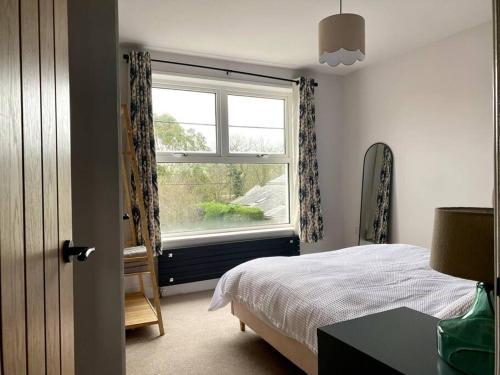 a bedroom with a bed and a window at Beautiful 3 Bedroom Home, North Cornwall in Saint Teath