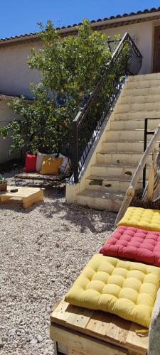 Cette chambre dispose d'un escalier et d'un lit avec des couvertures jaunes et rouges. dans l'établissement Les citronniers et les mimosas, à Hyères