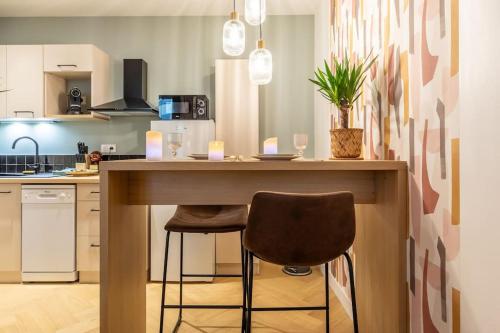 une cuisine avec un comptoir et deux chaises au bar dans l'établissement Loveroom en centre ville avec jacuzzi - Notre dame, à Clermont-Ferrand