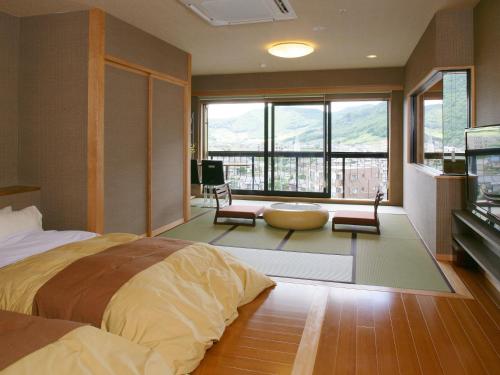 a bedroom with a large bed and a large window at Fuji Hanayagi no Sho Keizan in Fuefuki