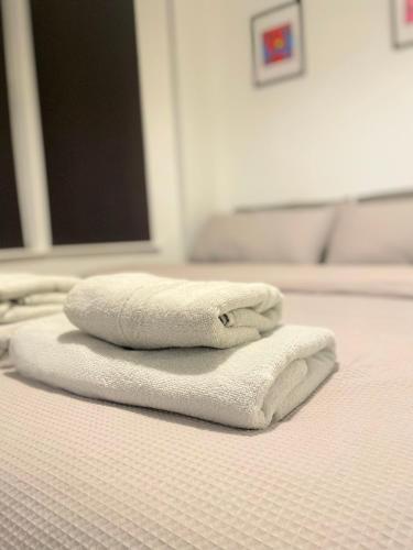 three towels sitting on top of a bed at Cosy Prenton home near Tranmere Club and Liverpool in Birkenhead