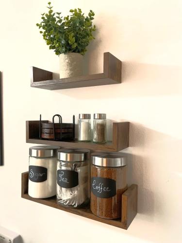 two shelves with pots and pans on a wall at Cosy Prenton home near Tranmere Club and Liverpool in Birkenhead