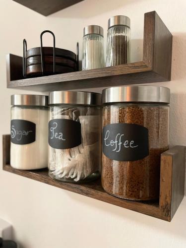 a shelf with four containers of spices on it at Cosy Prenton home near Tranmere Club and Liverpool in Birkenhead