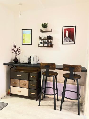 a desk and two stools in a room at Cosy Prenton home near Tranmere Club and Liverpool in Birkenhead