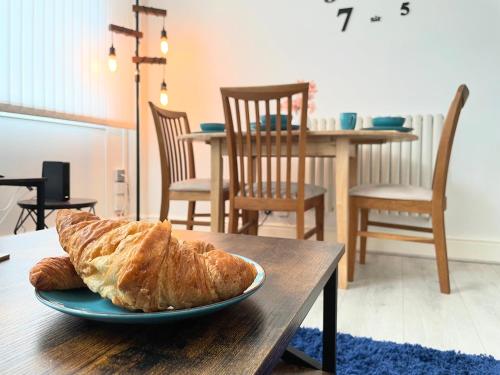 a plate of bread sitting on a wooden table at Cosy Prenton home near Tranmere Club and Liverpool in Birkenhead