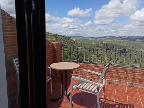 a table and chairs on a balcony with a view at Hotel Rural los Tadeos in Zahara de la Sierra