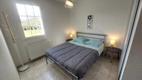 um quarto com uma cama com almofadas azuis e uma janela em L'Ecrin Meublé de tourisme classé 3 étoiles em La Bâtie-Neuve