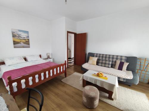 ein Schlafzimmer mit einem Bett und einem Sofa in der Unterkunft Apartman JOVO in Trebinje