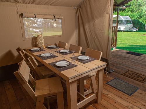 a wooden table and chairs in a tent at Safaritent Suikerpeer in Ruinerwold