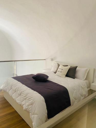 a bedroom with a large bed with black and white pillows at Luxury Loft 35 in Cagliari