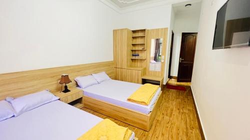 a bedroom with two beds and a book shelf at Khách Sạn Hoàng Nam-Cửa Lò-Nghệ An in Thương Xà (2)