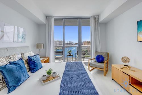 1 dormitorio con 1 cama grande con almohadas azules en Infinite View Balcony with Gym, Pool and Near Beach, en Hallandale Beach