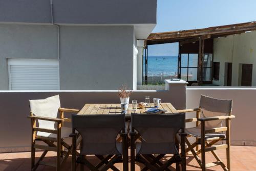 un tavolo e sedie su un patio con vista sull'oceano di Zoe's Place - 1 BD Beachfront Apartment a Kíssamos