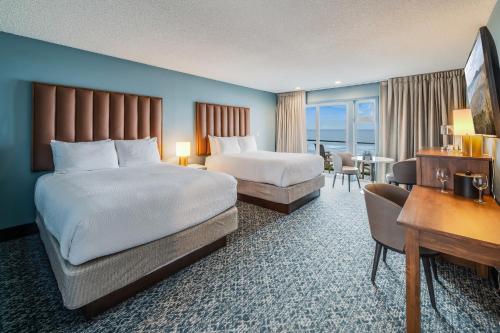 um quarto de hotel com duas camas e uma secretária em The Whaler em Newport