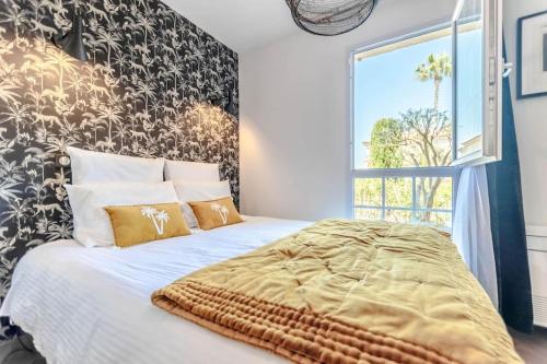 une chambre avec un grand lit avec une grande fenêtre dans l'établissement Anaïs de Saint-Tropez, Bel appartement, avec piscine et jardin, au cœur de Saint Tropez, à Saint-Tropez