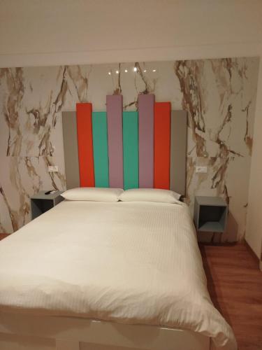 a bed with a colorful headboard in a room at Confort Suites in Reggio Calabria