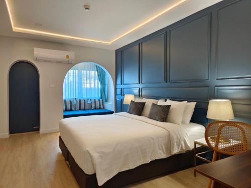 a bedroom with a large bed and a blue wall at Regent Ramkhamhaeng 22 in Bangkok