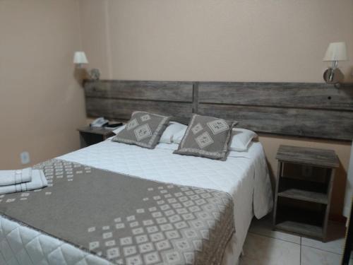 a bedroom with a bed with pillows on it at Mirante Hotel in Santa Vitória do Palmar