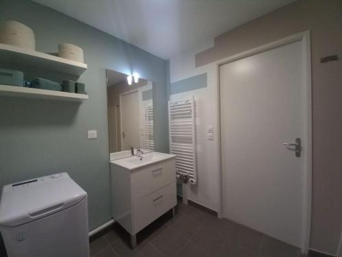 une salle de bain avec un lavabo blanc et un miroir dans l'établissement Appartement neuf bien situé à Sainte Cécile Plage, à Camiers