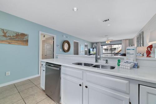 a kitchen with white cabinets and a sink at Bring Your Boat! 2br/2ba Condo on the Bay! in Orange Beach