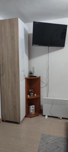 a room with a tv on the wall and a cabinet at Smeštaj Vrhovac in Vrdnik