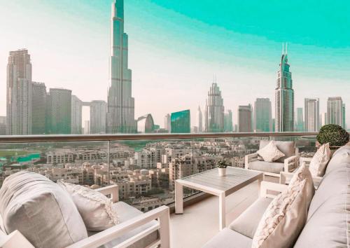 uma varanda com mobiliário branco e vista para a cidade em Elite Royal Apartment - Panoramic Full Burj Khalifa, Fountain & Skyline view - Infinite em Dubai