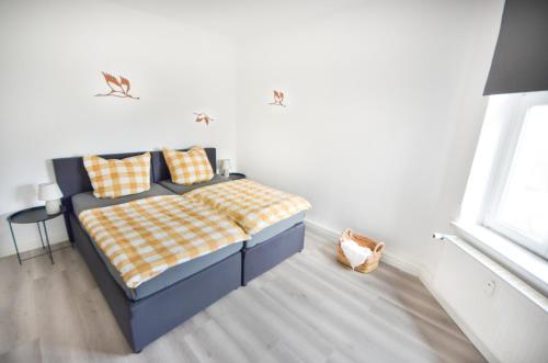 a bedroom with a bed with a checkered blanket at Apartmenthaus Fritz Reuter in Schwerin