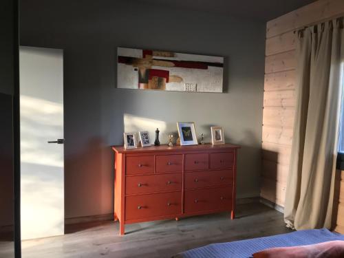a bedroom with a dresser with two pictures on it at Maison écologique de qualité supérieure in Monflanquin