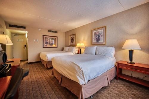 een hotelkamer met 2 bedden en een televisie bij Amenida Residences, Calgary in Calgary