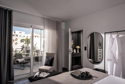 una camera da letto con un letto, una sedia e uno specchio di Icos City 1 a Hersonissos