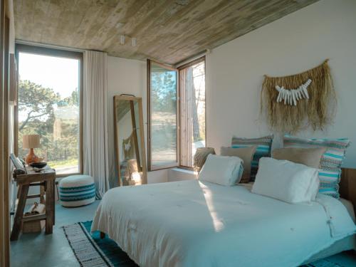 Un dormitorio con una cama grande y una ventana grande. en Villa Amae Deluxe Comporta, en Carvalhal
