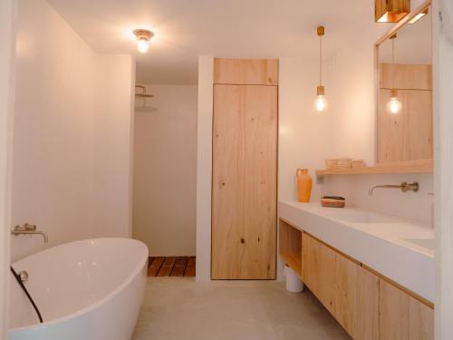 Baño blanco con bañera y 2 lavabos en Villa Amae Deluxe Comporta, en Carvalhal