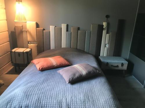 a bed with two pillows on it in a room at Maison écologique de qualité supérieure in Monflanquin